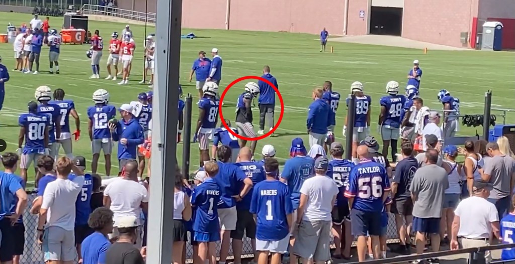 Screenshot of a football practice with players and spectators.